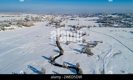 Drone shot de la rivière Schmutter serpentant naturellement à travers le paysage hivernal enneigé du parc naturel Western Forests près d'Augsbourg Banque D'Images