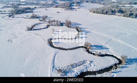 Drone shot de la rivière Schmutter serpentant naturellement à travers le paysage hivernal enneigé du parc naturel Western Forests près d'Augsbourg Banque D'Images