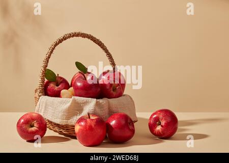 Les pommes fraîches sont placées à l'intérieur d'un panier en bambou sur fond pastel. Le produit extrait de la pomme (Malus domestica) réduit l'apparence de dar Banque D'Images