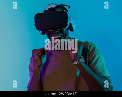 Homme afro-américain se plonge dans une expérience de jeu d'horreur palpitante en utilisant des lunettes VR, créant une atmosphère isolée et intense contre un Banque D'Images