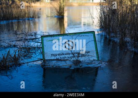 Panneau Avertissement de niveaux d'eau élevés, dans l'eau gelée, Green Park, Reading, Berkshire, Angleterre, Royaume-Uni, GB. Banque D'Images