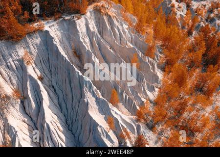 Vue aérienne d'une colline artificielle à partir de gravats en gros plan. Extraction de pierres concassées dans la forêt d'automne. Magnifiques pentes lavées par la pluie de décombres Banque D'Images