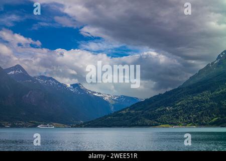 La vue de Innvikfjorden depuis le village de Loen, Norvège après une averse d'été près de l'heure du soir avec un curiship naviguant dans les eaux Banque D'Images