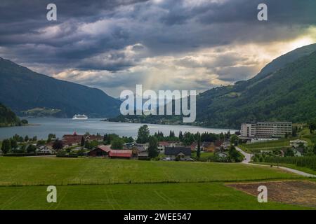 La vue de Innvikfjorden depuis le village de Loen, Norvège après une averse d'été près de l'heure du soir avec un curiship naviguant dans les eaux Banque D'Images