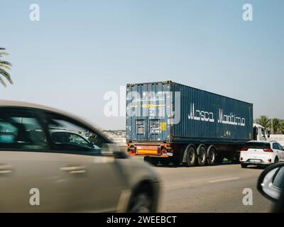 Majorque, Espagne - 27 juin 2023 : un conteneur maritime Mosca Maritimo chargé sur un camion, circulant dans les rues de Palma de Majorque, sous un ciel bleu clair, facilitant le transport sur l'île espagnole Banque D'Images