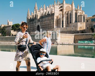 Majorque, Espagne - 27 juin 2023 : deux femmes et un enfant sont repérés marchant ensemble, poussant une poussette, dans les charmantes rues de Palma de Majorque. Banque D'Images