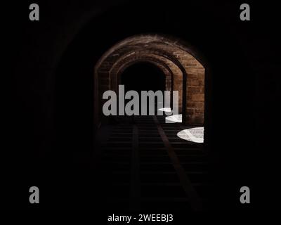 Découvrez l'enchantement d'un tunnel sombre avec un faisceau de lumière captivant à son extrémité à Majorque, Palma de Majorque, en Espagne, entouré par la magnifique architecture de Catedral-Baslica de Santa Maia, capturée à travers un objectif tilt-shift. Banque D'Images