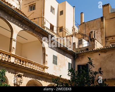 Un grand immeuble d'appartements à Palma de Majorque, orné de plusieurs colonnes, posé contre un ciel bleu clair, capturé sous un angle bas Banque D'Images