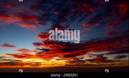 coucher de soleil impressionnant avec des nuages orange et rouges. la silhouette de la gomera en arrière-plan. 24 janvier 2024 Banque D'Images