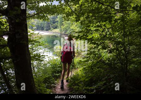 Femme marchant dans la campagne rurale avec sac à dos rouge - Bohinj, Parc National du Triglav - Slovénie Banque D'Images