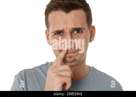 l'homme cueille son nez isolé sur fond blanc. Banque D'Images