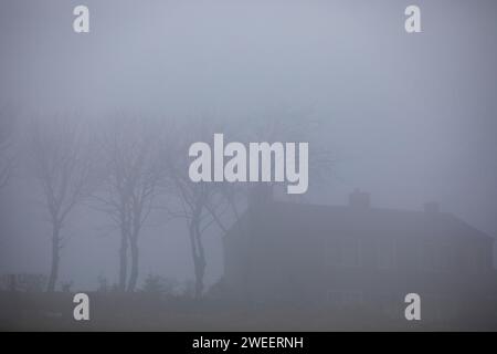 La brume sur une colline de Pennine près de Queensbury transforme les fermes et les marcheurs en silhouettes fantômes alors que le temps hivernal saisonnier de janvier se rapproche. Banque D'Images