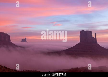 Lever de soleil coloré avec brouillard au sol dans le Monument Valley Navajo Tribal Park en Arizona. Banque D'Images