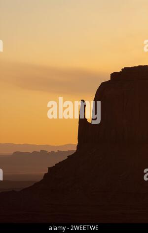 Ciel de lever de soleil pastel derrière l'East Mitten Butte dans le Monument Valley Navajo Tribal Park en Arizona. Banque D'Images