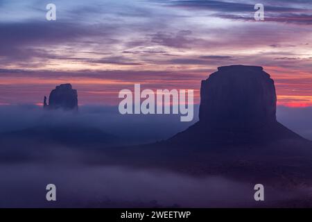 Lever de soleil brumeux dans le Monument Valley Navajo Tribal Park en Arizona. Banque D'Images