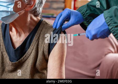 femme âgée recevant le vaccin à domicile Banque D'Images