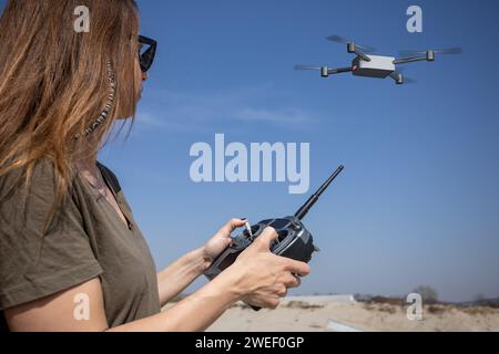 jeune femme volant un drone avec télécommande Banque D'Images