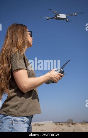 jeune femme volant un drone avec télécommande Banque D'Images