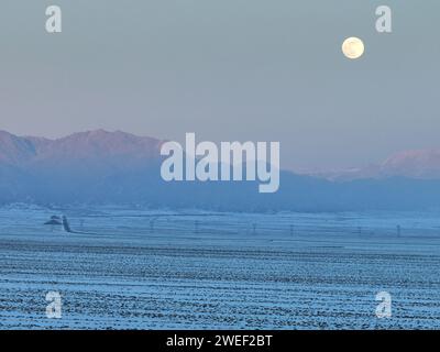 HAMI, CHINE - 25 JANVIER 2024 - Une lune brillante se lève au-dessus des montagnes de Tianshan est à Hami, province du Xinjiang, Chine, 25 janvier 2024. Le premier plein Banque D'Images