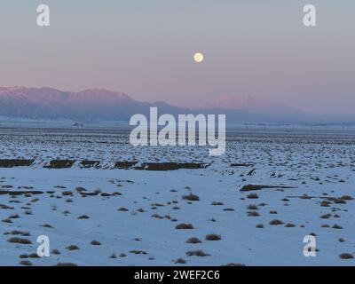 HAMI, CHINE - 25 JANVIER 2024 - Une lune brillante se lève au-dessus des montagnes de Tianshan est à Hami, province du Xinjiang, Chine, 25 janvier 2024. Le premier plein Banque D'Images