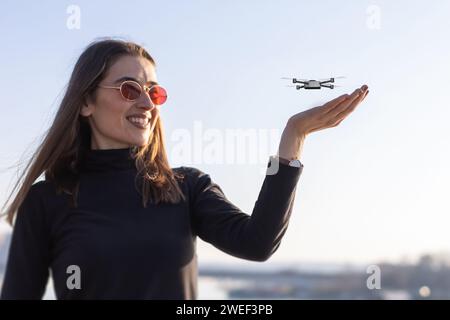 minuscule drone atterrissant sur la paume de la jeune femme Banque D'Images