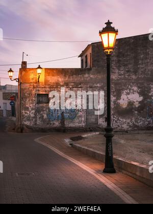 San Miguel de Salinas, Alicante - Espagne. Calle San Juan, une rue de San Miguel de Salinas, éclairée par des lampadaires au coucher du soleil un soir de janvier. Banque D'Images