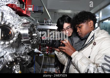 (240125) -- HEFEI, 25 janvier 2024 (Xinhua) -- Yang Yuanfan (L) et un étudiant international de Madagascar créent un produit de visualisation scientifique à l'Université des sciences et technologies de Chine à Hefei, dans la province d'Anhui, dans l'est de la Chine, le 29 décembre 2023. Yang Yuanfan, 27 ans, étudiant au doctorat à l'Université des sciences et de la technologie de Chine (USTC), est le fondateur de Anhui Shengke Culture Technology Co., Ltd Les étudiants de l'USTC et les diplômés qui ont étudié à l'étranger, seize au total, constituent l'entreprise. En 2022, Yang Yuanfan a lancé sa propre entreprise dans la région de Shushan de la Grande Union Banque D'Images