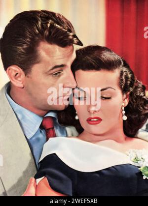 Portrait de Robert Mitchum et Jane Russell, stars du film "HIS Kind of Woman" (1951). Dans ce film noir, Mitchum joue Dan Milner, un joueur perplexe qui se retrouve impliqué dans un complot complexe impliquant le crime et l'intrigue. Russell dépeint Lenore Brent, une chanteuse et amoureuse de Milner. Situé dans une station balnéaire mexicaine glamour, le film allie suspense, romance et humour noir. Banque D'Images