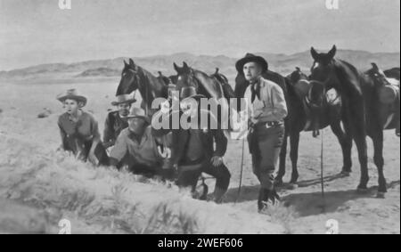 Virginia Mayo, Walter Brennan et Kirk Douglas jouent dans 'Along the Great Divide' (1951), un film occidental. Dans ce film, Kirk Douglas joue Len Merrick, un maréchal américain qui sauve un meurtrier accusé, Tim 'Pop' Keith, interprété par Walter Brennan, d'une foule de lynchages. Virginia Mayo joue Ann Keith, la fille de Tim, qui s'implique dans le voyage qui s'ensuit. Le film se concentre sur leur randonnée à travers le désert pour amener Tim à un procès, face à divers dangers et dilemmes moraux en cours de route. Banque D'Images