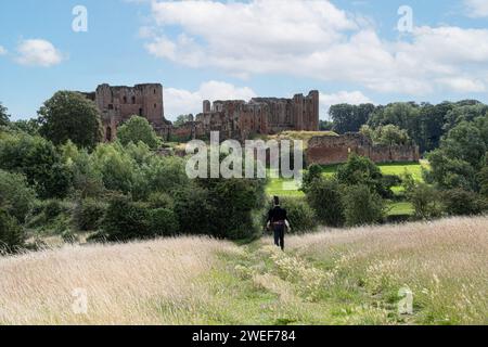 Kenilworth Angleterre 07 29 2023 un homme costumé médiéval solitaire marchant vers le château Banque D'Images
