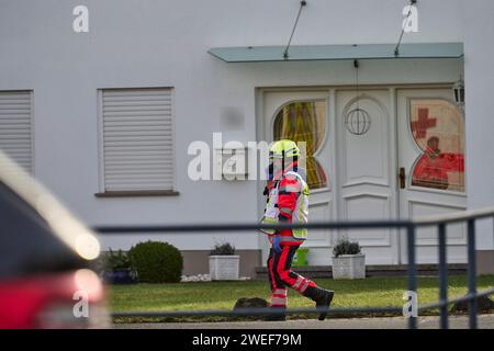 Montabaur, Allemagne. 25 janvier 2024. Un paramédical court devant un immeuble résidentiel après l'attaque. Selon la police, trois personnes, dont un enfant, ont été tuées dans une violente attaque dans un quartier résidentiel. Les services d’urgence ont découvert que l’auteur présumé avait été grièvement blessé après être entré dans le bâtiment, selon un porte-parole de la police. Credit : Sascha Ditscher/dpa - ATTENTION : le numéro de maison a été pixelisé pour des raisons juridiques/dpa/Alamy Live News Banque D'Images