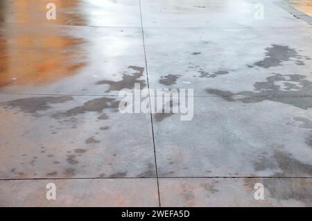 Gros plan d'humité sur le sol de la rue. Plancher mouillé de pluie .danger accident sur le trottoir du concept de danger de plancher glissant. Banque D'Images