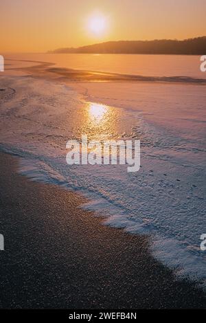 Un lac gelé pendant un beau coucher de soleil Banque D'Images