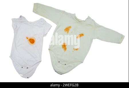 Body de vêtements pour enfants avec des taches orange de purée de légumes sur fond blanc, isolez. Concept de détachant à l'oxygène Banque D'Images