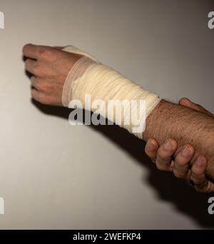 Blessure masculine à la main gauche avec bandage Banque D'Images