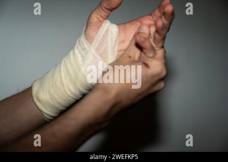 Blessure masculine à la main gauche avec bandage Banque D'Images