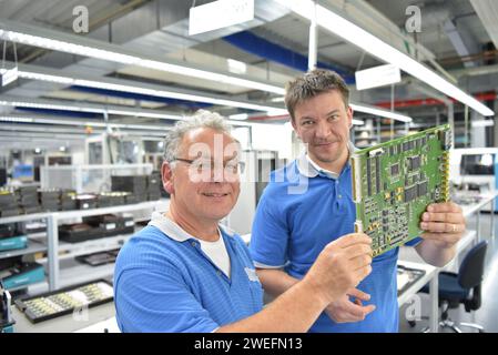 travailler dans une usine de fabrication de microélectronique - assemblage de composants et soudure - groupe de travailleurs au travail d'équipe Banque D'Images