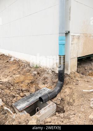 Le tuyau de drainage temporaire du toit du bâtiment au tuyau de drainage en béton sur le chantier de construction, vue de face avec l'espace de copie. Banque D'Images