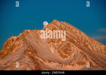 Montagne enneigée avec lune montante Banque D'Images