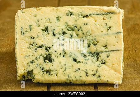 Un morceau de fromage Roquefort posé sur une table en bois Banque D'Images