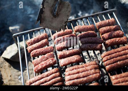 Griller la viande sur un barbecue avec du charbon chaud. Nourriture traditionnelle dans les Balkans. Banque D'Images