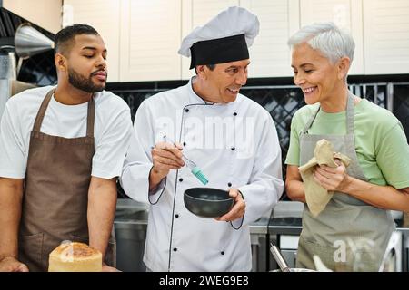 joyeuse femme mature et homme afro-américain apprenant à cuisiner avec chef joyeux, cours de cuisine Banque D'Images