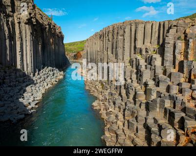 Canyon de magnifiques colonnes de basalte, haute falaise avec rivière turquoise brillante, dans le nord-est de l'Islande, prise de vue aérienne. Studlagil, concept de beauté de la nature. Banque D'Images