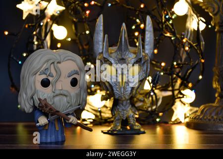 Funko Pop figurines d'action du magicien Gandalf le gris et le Seigneur Noir Sauron du film fantastique le Seigneur des anneaux. Éclairage chaud, fond noir. Banque D'Images