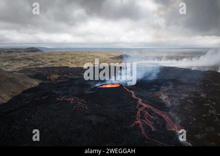 Environnement apocalyptique d'un volcan en éruption, lave rouge bouillant et déversant le cratère, gaz volcaniques et fumée se propageant autour de la zone Banque D'Images