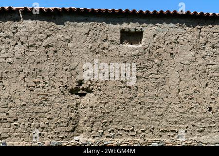 Mur d'adobe en argile ancienne plâtré comme fond naturel. Stuc brun, vieux mur Banque D'Images