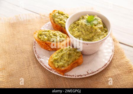 Petit déjeuner grillé à l'avocat écrasé. Toasts d'avocat écrasés. Alimentation saine, régime, nourriture végétarienne végétalienne savoureuse. Servi sur assiette blanche. Recette facile pour h Banque D'Images