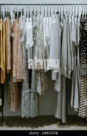 Vêtements suspendus sur des étagères dans un magasin de mode. Banque D'Images