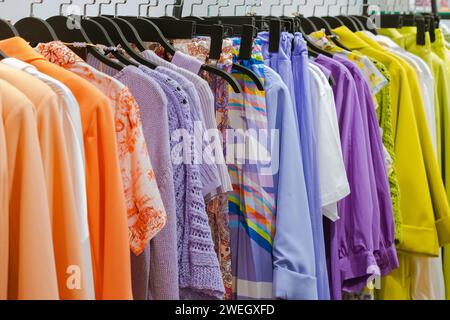 Vêtements pour femmes accrochés sur des cintres sur le comptoir de la dernière collection saisonnière du magasin Banque D'Images