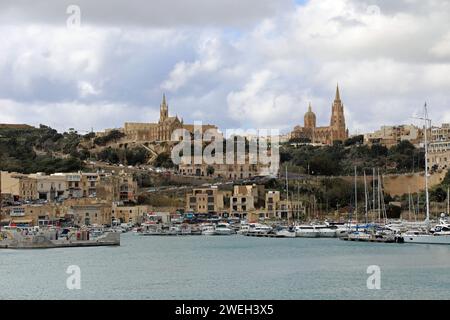 Village de pêcheurs og Mgarr avec l'église de Sainte mère Lurdskaya sur la ligne d'horizon Banque D'Images